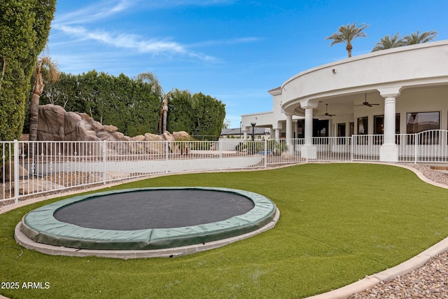 view of yard with a trampoline and ceiling fan