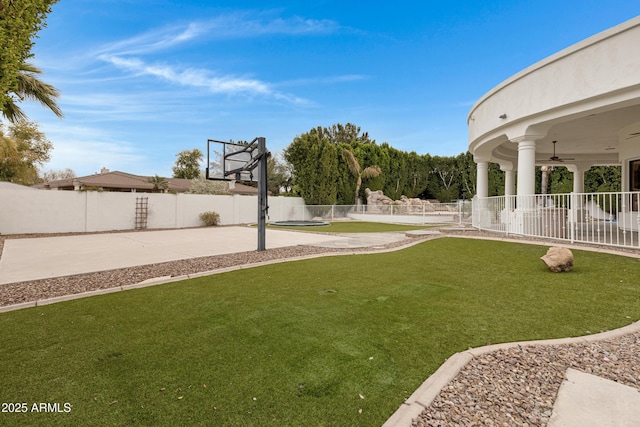 view of yard featuring ceiling fan and basketball court