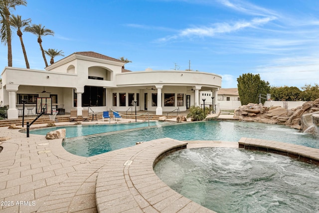 view of swimming pool with pool water feature, a patio, ceiling fan, and an in ground hot tub