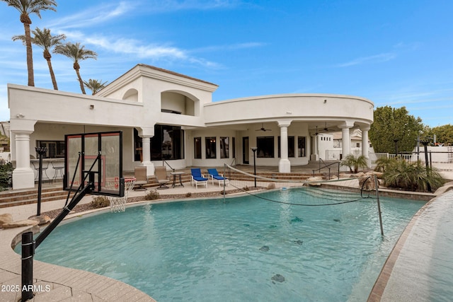 back of house with ceiling fan, a community pool, and a patio