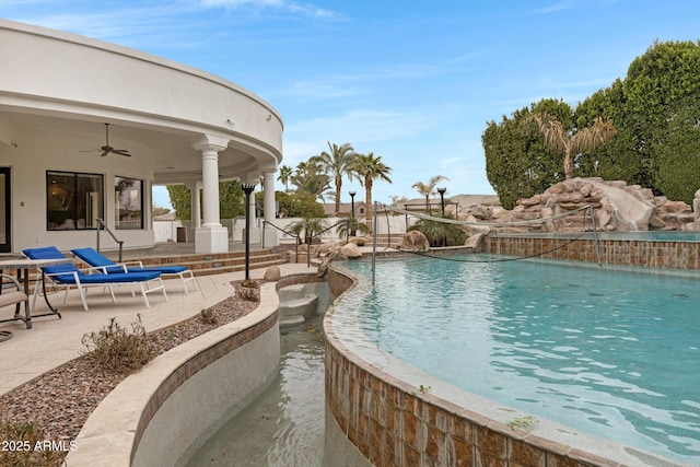 view of swimming pool with pool water feature, ceiling fan, and a patio