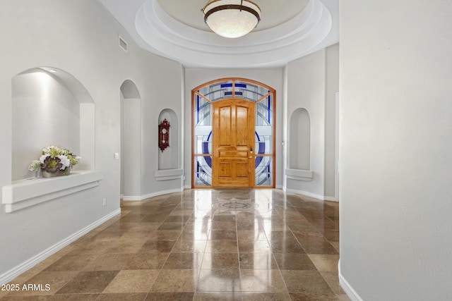 entrance foyer with a raised ceiling and a high ceiling