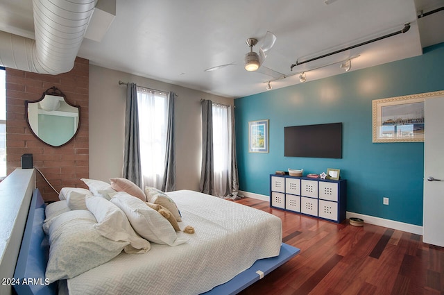 bedroom featuring track lighting, ceiling fan, and dark hardwood / wood-style flooring