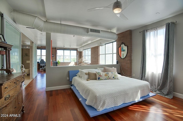 bedroom with baseboards, wood finished floors, visible vents, and multiple windows