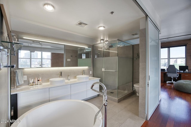 bathroom featuring double vanity, visible vents, a stall shower, and a sink