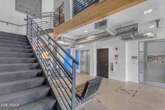 stairs with speckled floor, baseboards, elevator, and visible vents