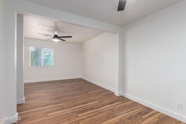 unfurnished room with baseboards, wood finished floors, and a ceiling fan