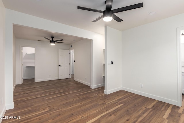 unfurnished room with a ceiling fan, dark wood-style flooring, and baseboards