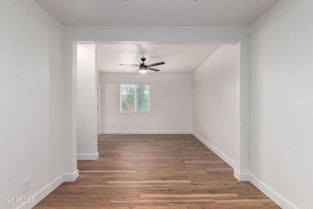 unfurnished room featuring a ceiling fan, baseboards, and wood finished floors