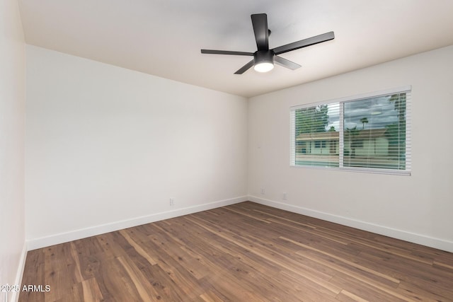 spare room with a ceiling fan, wood finished floors, and baseboards