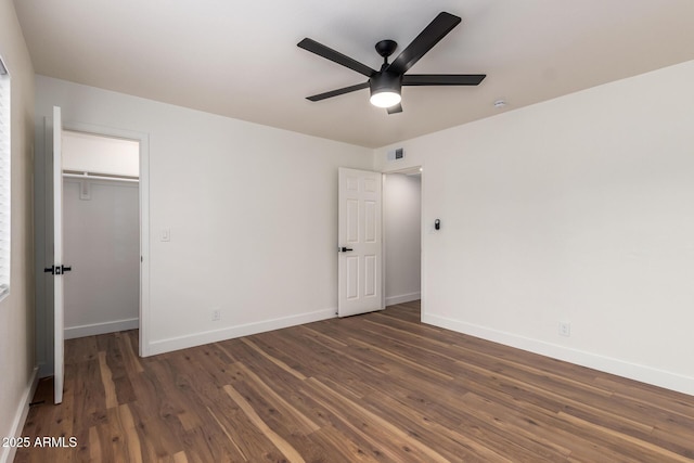 unfurnished bedroom with dark wood finished floors, visible vents, a closet, and baseboards