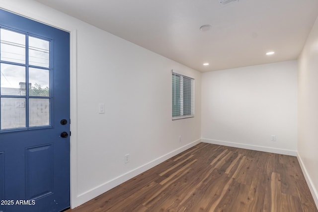 empty room with dark wood finished floors, visible vents, recessed lighting, and baseboards