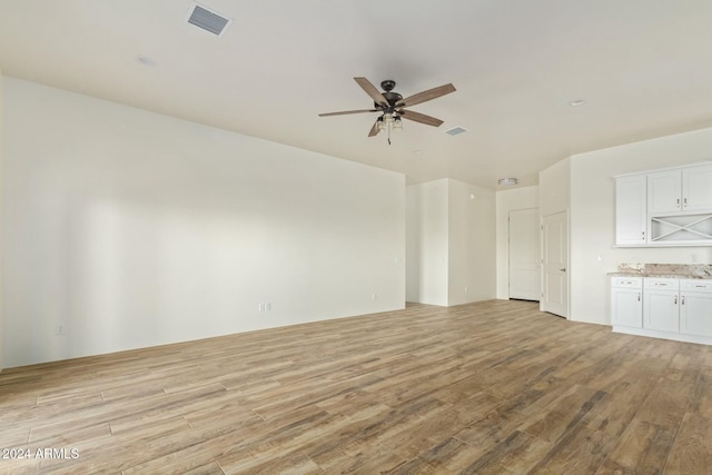 unfurnished living room featuring ceiling fan and light hardwood / wood-style flooring