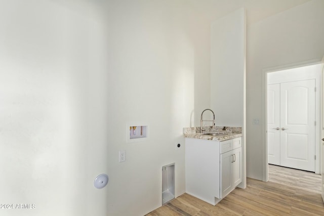 laundry room with washer hookup, sink, hookup for an electric dryer, and light wood-type flooring