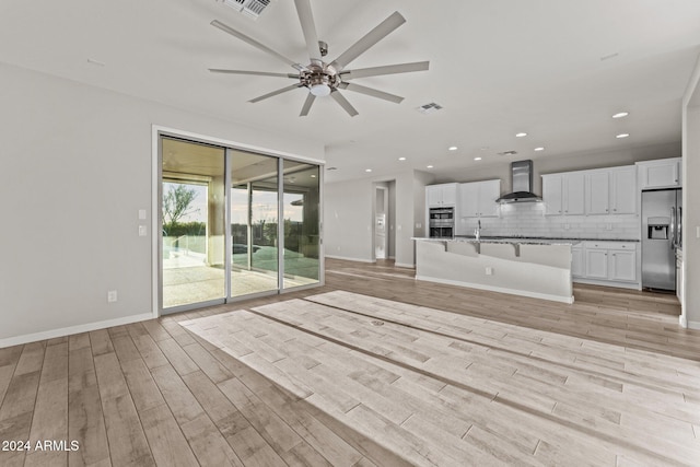 unfurnished living room featuring light wood-type flooring and ceiling fan