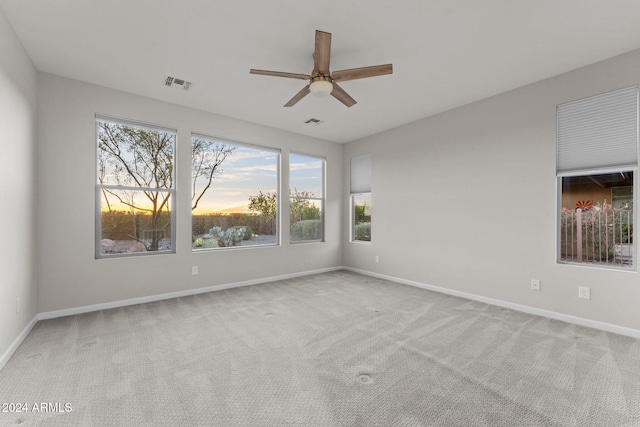 spare room featuring light carpet and ceiling fan