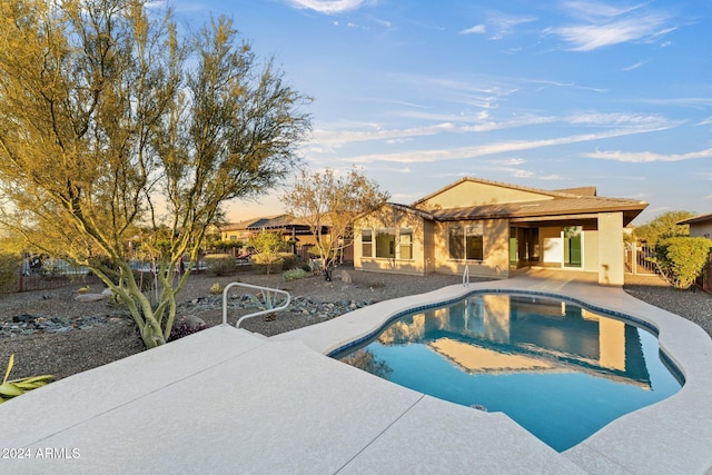 pool at dusk featuring a patio area