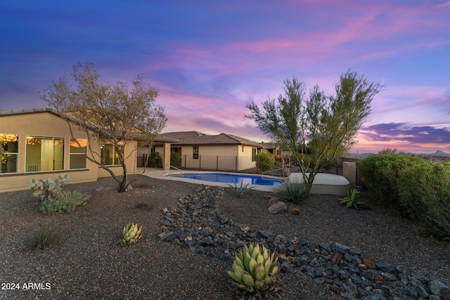 pool at dusk featuring a patio area