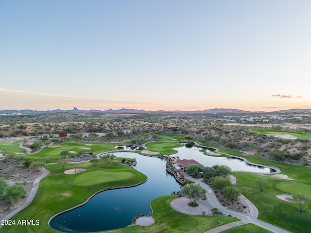 aerial view at dusk featuring a water and mountain view