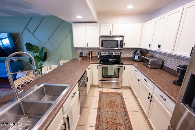 16021 N 30th St Unit 127, Phoenix, AZ 85032 - kitchen with stainless steel appliances, backsplash, light tile patterned floors, white cabinets, and recessed lighting