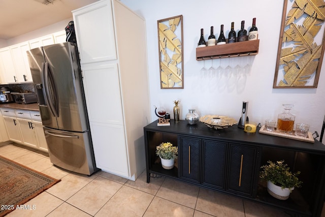 16021 N 30th St Unit 127, Phoenix, AZ 85032 - kitchen featuring stainless steel fridge with ice dispenser, white cabinets, light tile patterned floors, and dark countertops