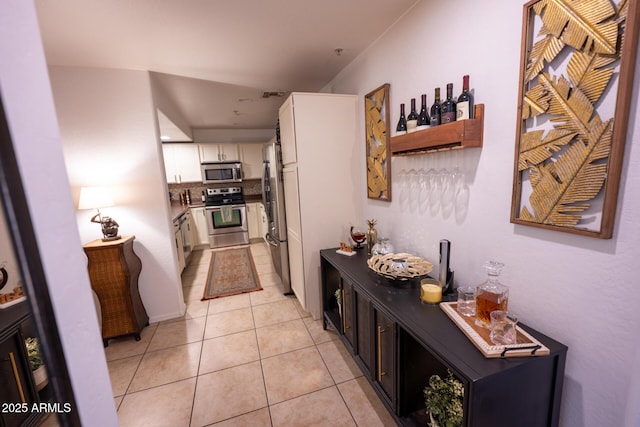 16021 N 30th St Unit 127, Phoenix, AZ 85032 - kitchen featuring appliances with stainless steel finishes, backsplash, white cabinets, and light tile patterned flooring