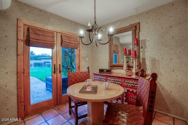 tiled dining space featuring a chandelier and french doors