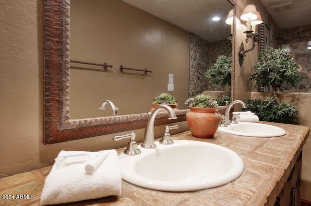 full bathroom with double vanity, visible vents, and a sink