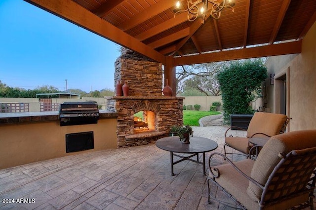 view of patio with a gazebo, area for grilling, an outdoor stone fireplace, and fence