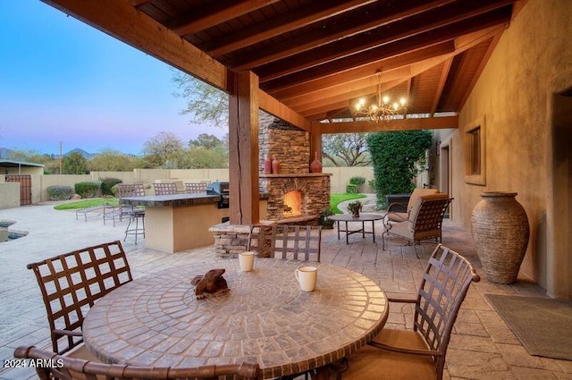 view of patio featuring outdoor dry bar, an outdoor stone fireplace, and a fenced backyard