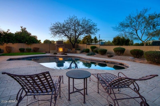 view of pool featuring a patio and an outdoor fireplace