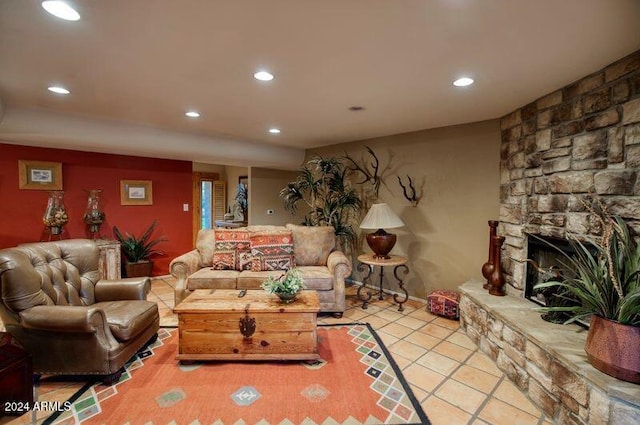 living room with recessed lighting, a stone fireplace, and light tile patterned floors