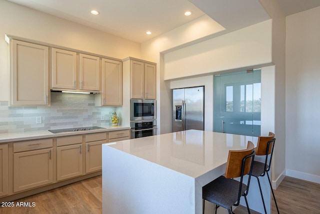 16248 E Ridgeline Dr, Fountain Hills, AZ 85268 - kitchen with light wood-type flooring, backsplash, a kitchen bar, and appliances with stainless steel finishes
