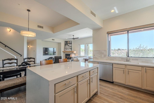 16248 E Ridgeline Dr, Fountain Hills, AZ 85268 - kitchen featuring a ceiling fan, stainless steel dishwasher, a sink, decorative backsplash, and a fireplace