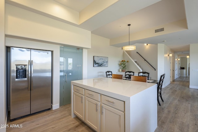 16248 E Ridgeline Dr, Fountain Hills, AZ 85268 - kitchen with white cabinets, light wood finished floors, stainless steel fridge with ice dispenser, visible vents, and decorative light fixtures