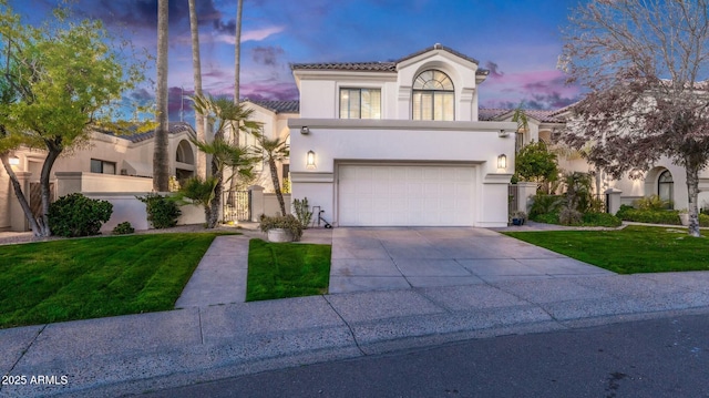 mediterranean / spanish-style house with a lawn and a garage