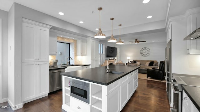 kitchen with a center island with sink, sink, ceiling fan, white cabinetry, and stainless steel appliances