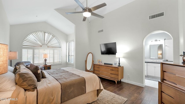 bedroom featuring lofted ceiling, ensuite bathroom, ceiling fan, and dark wood-type flooring