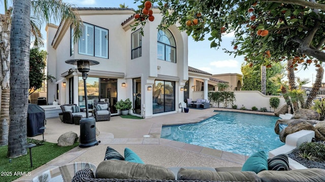 back of house featuring a fenced in pool, an outdoor hangout area, and a patio