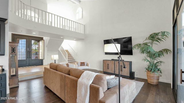 living room with french doors, dark wood-type flooring, and a high ceiling