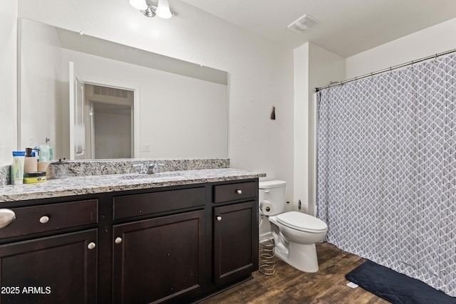 full bath featuring vanity, a shower with shower curtain, wood finished floors, visible vents, and toilet