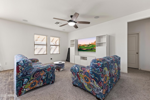 carpeted living area with baseboards, visible vents, and ceiling fan