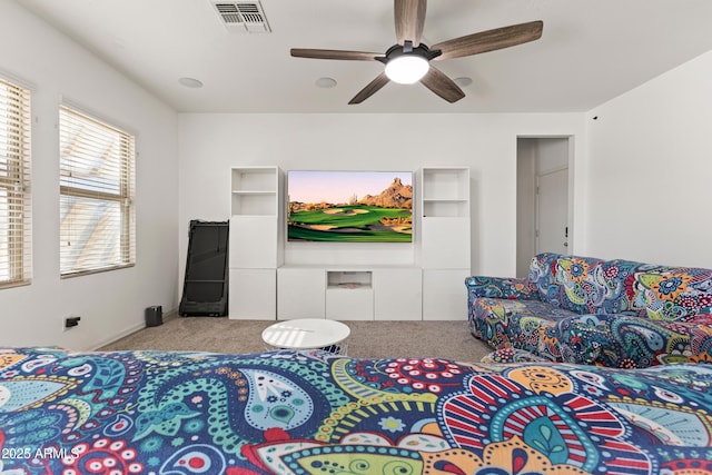 carpeted living area featuring a ceiling fan and visible vents