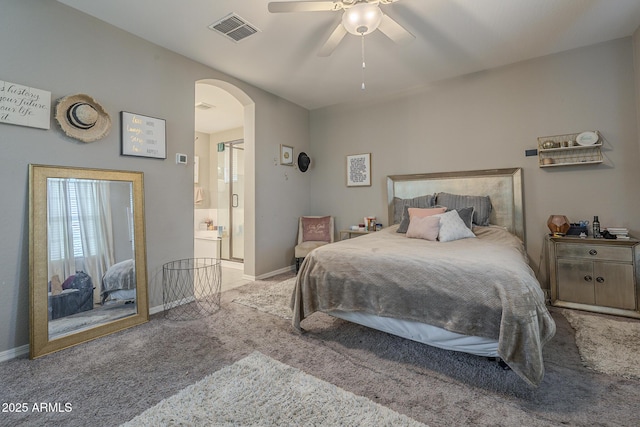 bedroom featuring light carpet, ceiling fan, and ensuite bath