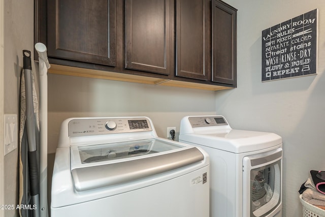 laundry room featuring cabinets and washing machine and clothes dryer