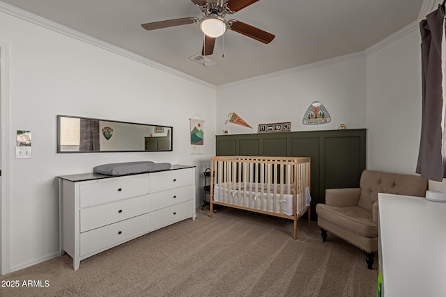 bedroom featuring light carpet, visible vents, ceiling fan, ornamental molding, and a nursery area