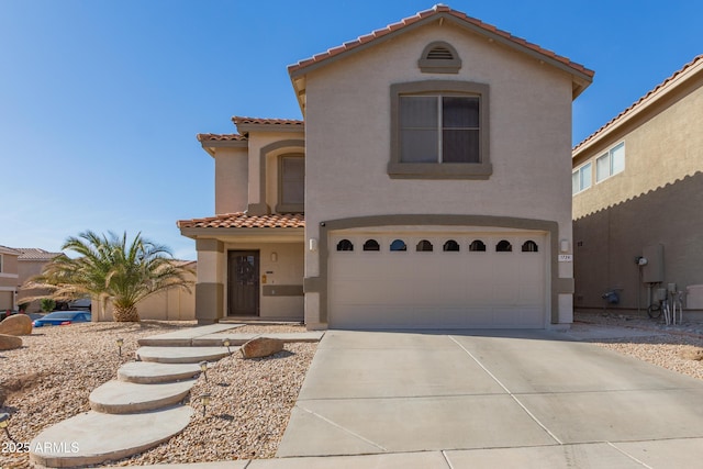 mediterranean / spanish house featuring a garage, concrete driveway, and stucco siding