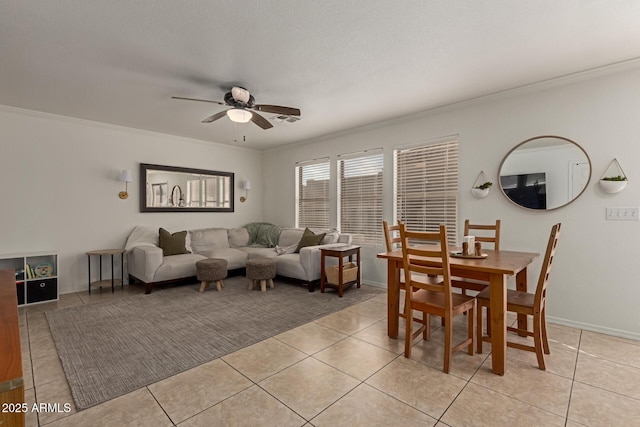 dining room with light tile patterned floors, ceiling fan, ornamental molding, and baseboards