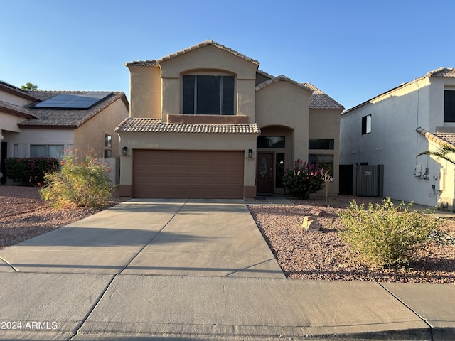 mediterranean / spanish-style home with stucco siding, concrete driveway, an attached garage, and a tile roof