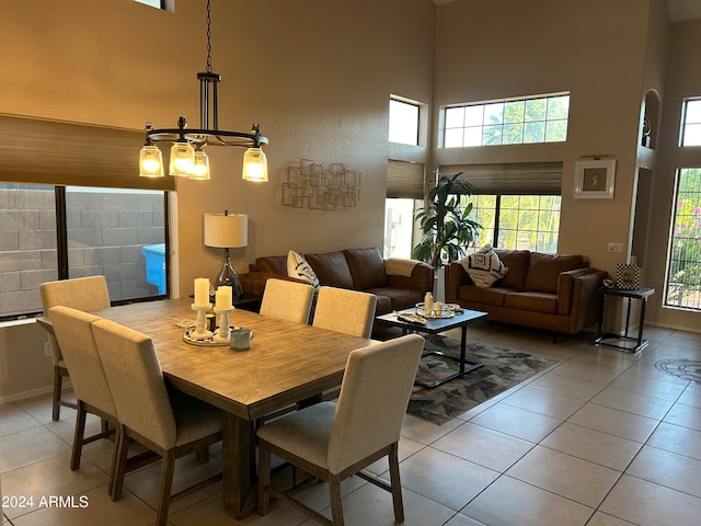 dining area featuring a healthy amount of sunlight, a towering ceiling, and light tile patterned floors